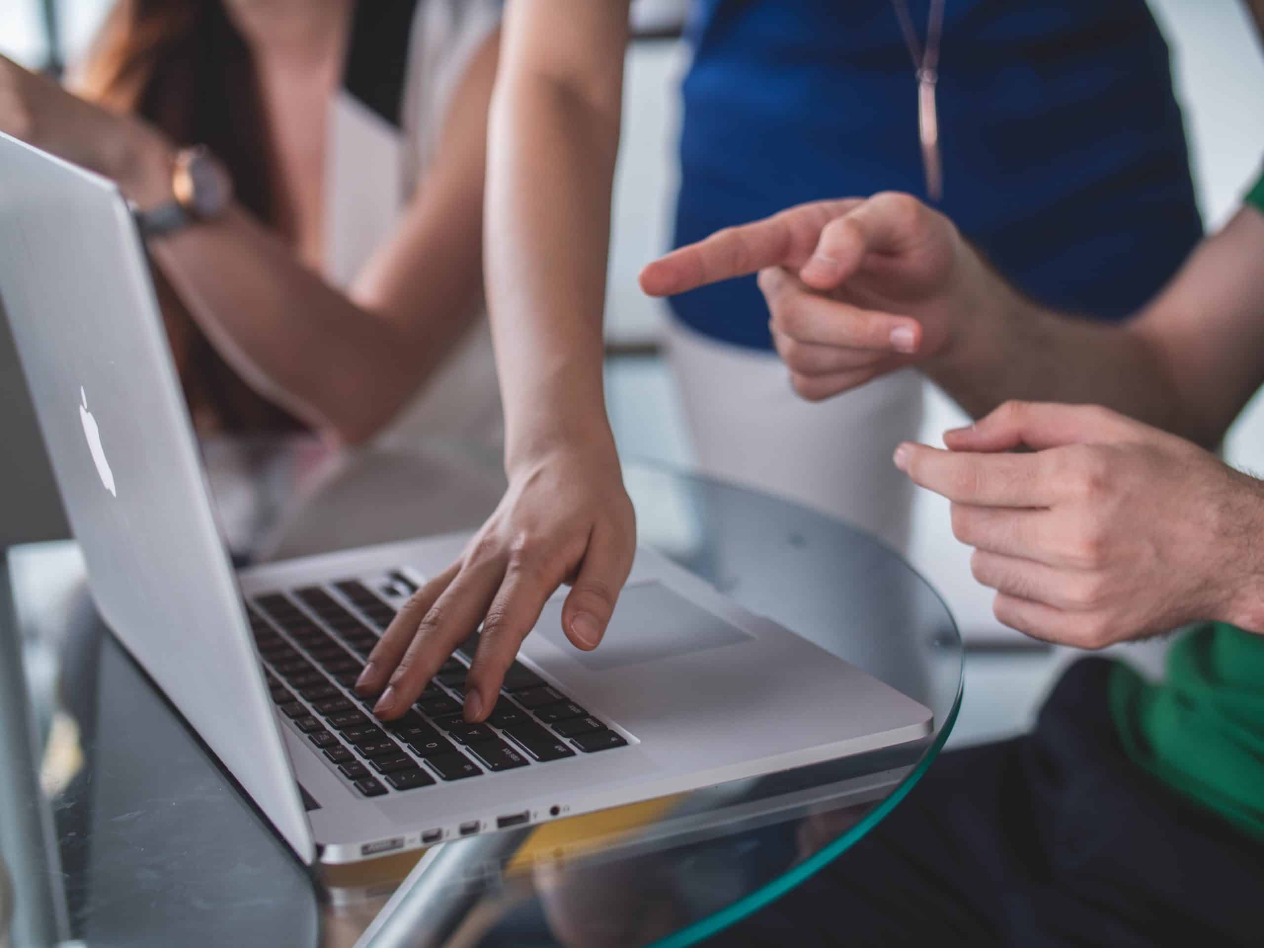 Fingers pointing at a laptop