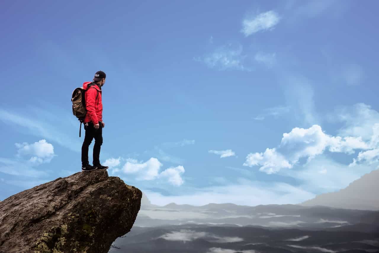 A man on top of a mountain overlooking the scenery