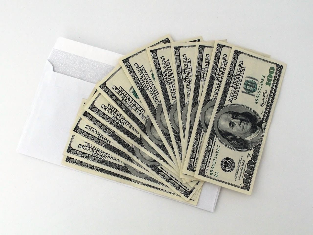 $100 bills on top of an envelope