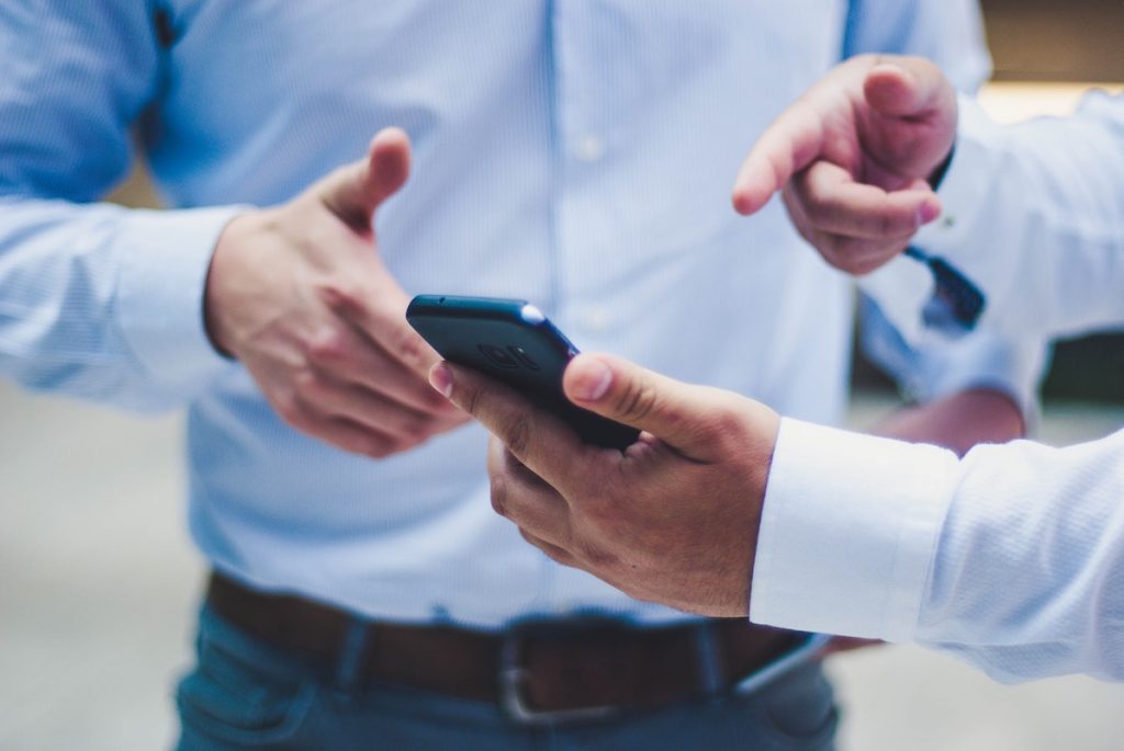 A man selling his phone to someone else.