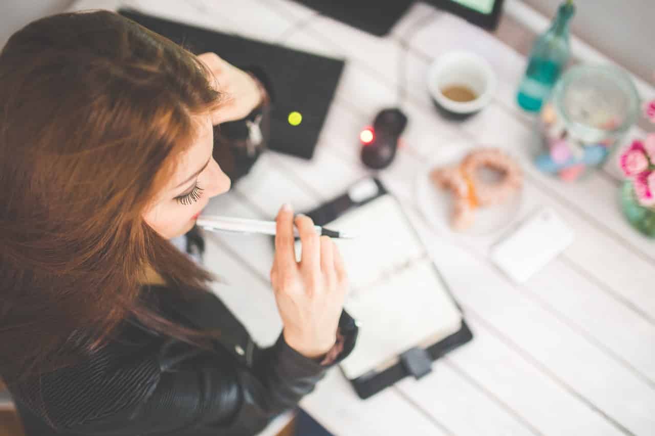 Girl biting her pen while journaling