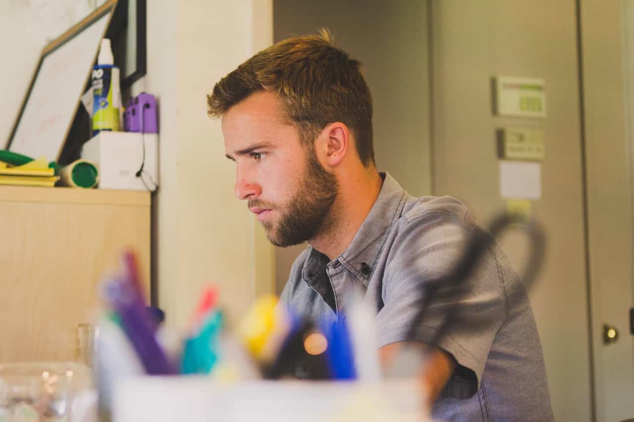 A man in his door looking at the computer